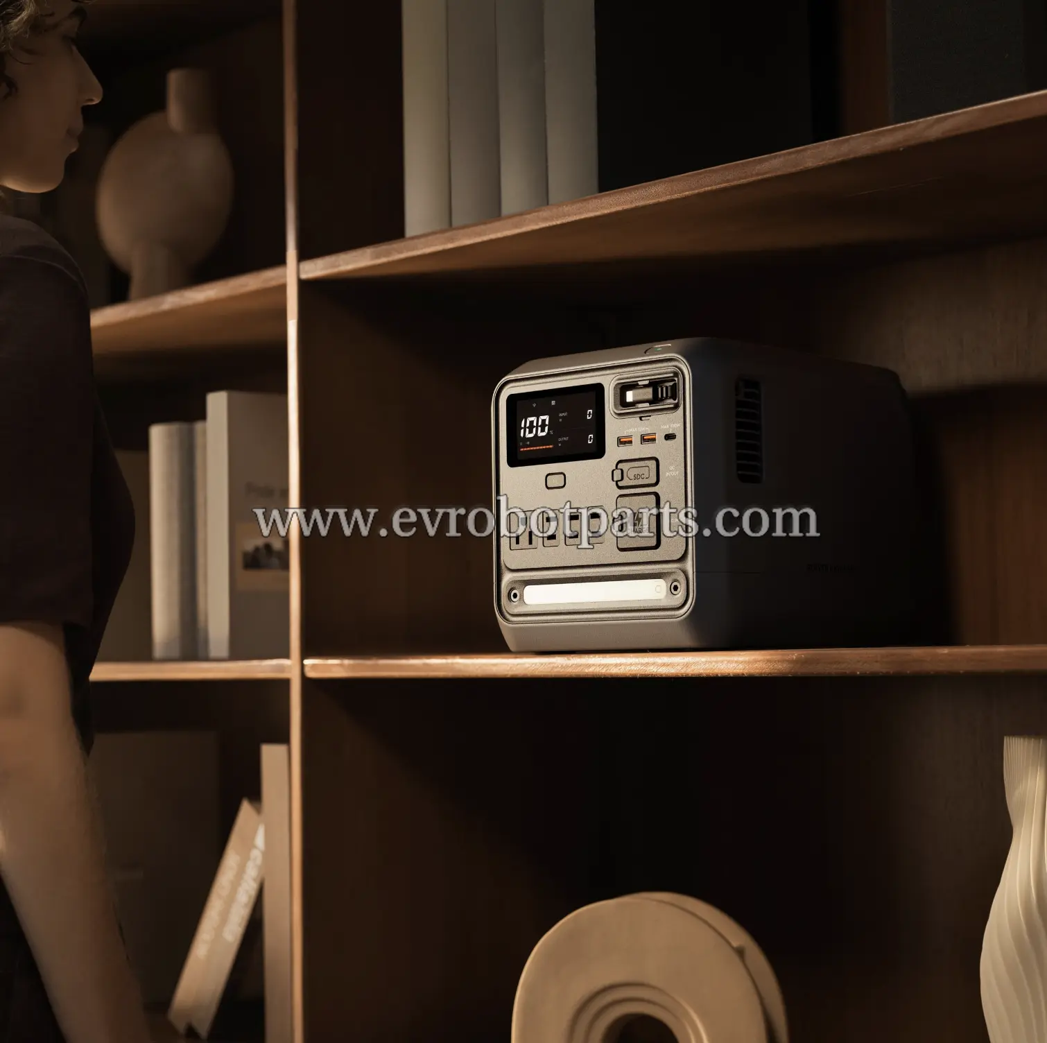 DJI Power 1000 Mini portable power station on wooden shelf in home environment with digital display showing 100% charge